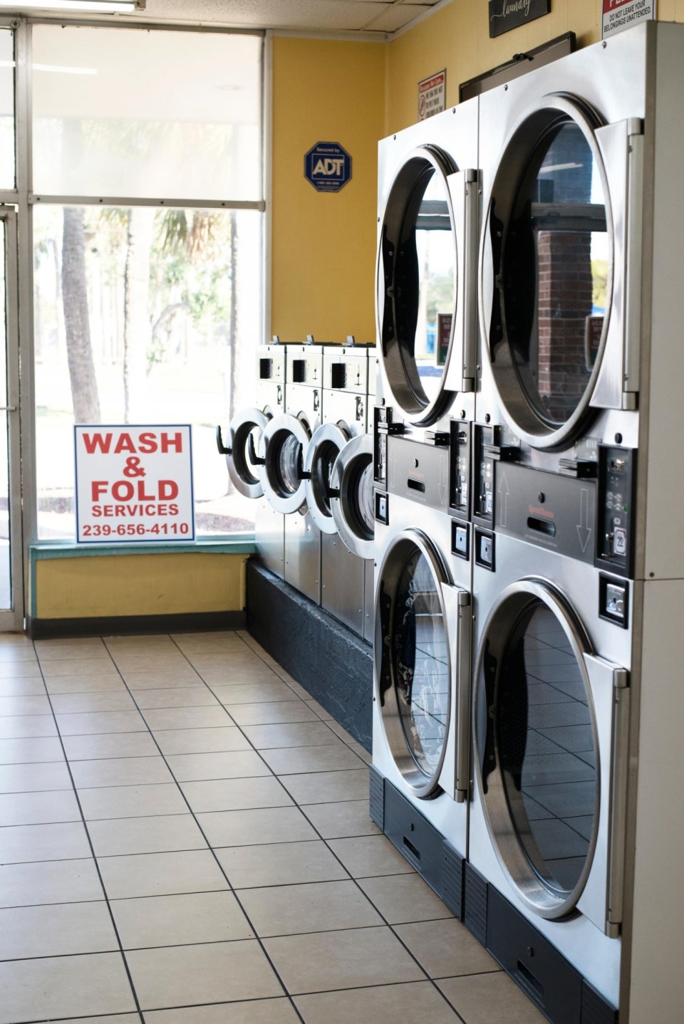 Stacked dryers next to the wash and fold service sign