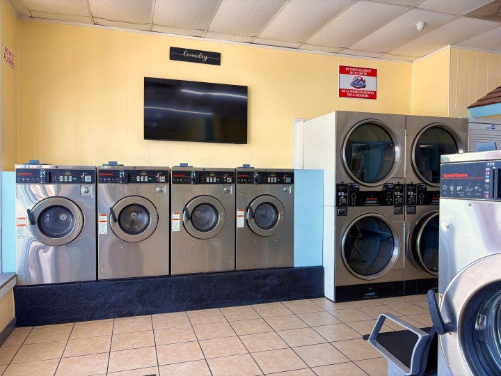 Front-load washers and wall-mounted TV inside Bright N Clean Laundromat